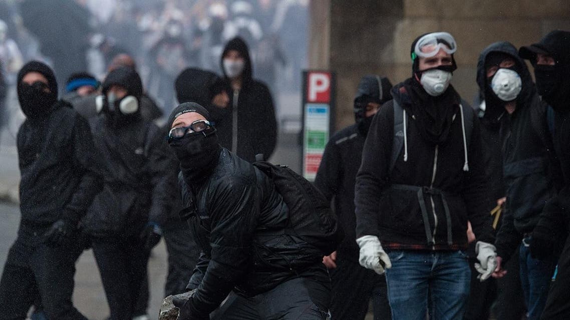 People throw stones towards the prefecture during a protest by the 'Yellow Vest' (gilets jaunes) anti-government movement as part of a nationwide multi-sector strike against the French government's pensions overhaul, on January 11, 2020 in Nantes, western France. (AFP)