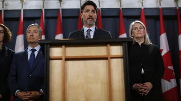 Canadian Minister of Foreign Affairs François-Philippe Champagne (L) and Deputy Minister of Defense Jody Thomas (R) listens as Prime Minister Justin Trudeau C) speaks during a news conference on January 11, 2020 in Ottawa, Canada. (AFP)