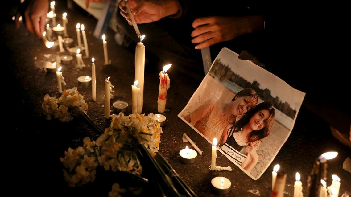 Candles sit in front of a picture of a victim at a candlelight vigil to remember those killed in the Ukraine plane crash, at the gate of Amri Kabir University that some of the victims of the crash were former students of. (AP)