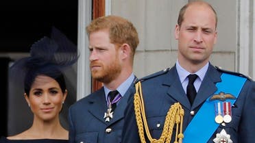 (L-R) Britain's Meghan, Duchess of Sussex, Britain's Prince Harry, Duke of Sussex, and Britain's Prince William, Duke of Cambridge, stand on the balcony of Buckingham Palace to watch a military fly-past to mark the centenary of the Royal Air Force (RAF). (AFP)