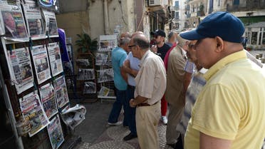 People view the covers of national and foreign newspapers, with the announced Algerian presidential election date dominating headlines, at a stand in Algeria's capital Algiers on September 16, 2019. Algeria is to hold presidential elections on December 12, five months into a political vacuum since longtime leader Abdelaziz Bouteflika resigned in the face of mass protests, his interim successor announced on September 15. The announcement comes after army chief General Ahmed Gaid Salah, seen as Algeria's strongman since the fall of the ailing Bouteflika, insisted that polls be held by the end of 2019, despite ongoing protests demanding the creation of new institutions ahead of any elections.
