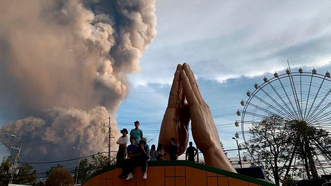 People watch as the Taal volcano spews ash and smoke during an eruption in Tagaytay, Cavite province south of Manila, Philippines on Sunday. Jan. 12, 2020. (Photo: AP)