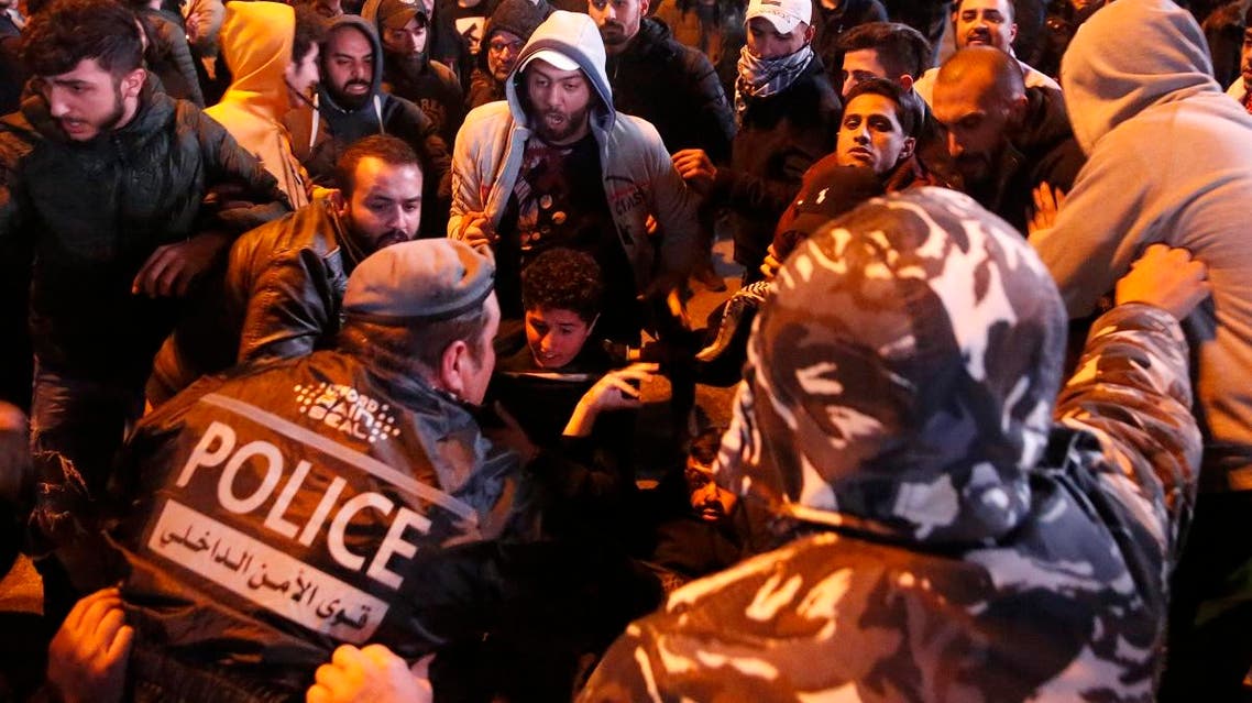 Lebanese policemen try to remove anti-government protesters to reopen a main road that was closed during ongoing protests against the ruling elite of corruption and financial crisis, in Beirut, Lebanon, Monday, Jan. 13, 2020. (AP)