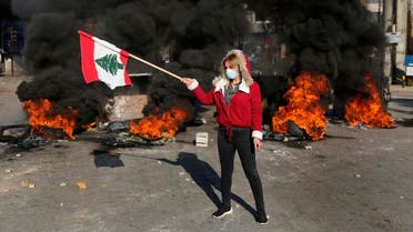 An anti-government protester waves a national flag during ongoing protests after weeks of calm in Beirut, Lebanon, Tuesday, Jan. 14, 2020. (Photo: AP)