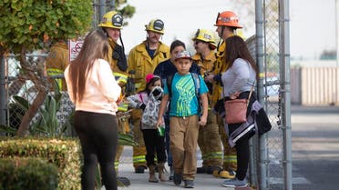 Children evacuate the Park Avenue Elementary school in Cudahy, Calif., after an aircraft dumped fuel that fell onto the elementary school playground. (Photo: AP)