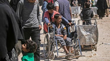 A child displaced from Syria's eastern Deir Ezzor province, pushes a young boy on a wheelchair in al-Hol camp for displaced people, in al-Hasakeh governorate in northeastern Syria on April 18, 2019. Dislodged in a final offensive by a Kurdish-led ground force and coalition air strikes, thousands of wives and children of IS fighters have flooded in from a string of Syrian villages south of the al-Hol camp in recent months.