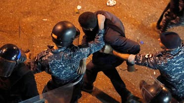 Riot police arrest an anti-government protester who was protesting outside a police headquarters demanding the release of those taken into custody the night before. (AP)