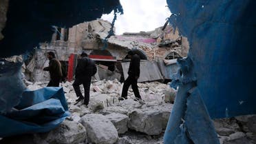 People walk past destruction by the government airstrikes in the town of Ariha, in Idlib province, Syria, on January 15, 2020. (AP)