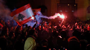 Anti-government demonstrators hold flares and Lebanese flags, during a protest on a road leading to the parliament building in Beirut, Lebanon, Thursday, Jan. 16, 2020. (AP)