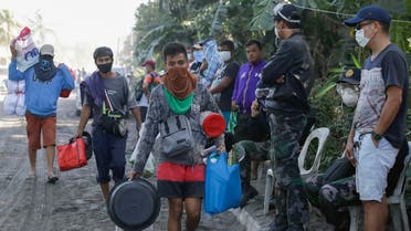 Men carry their belongings as authorities enforced total evacuation of residents living near the active Taal volcano in Agoncillo town. (AP)