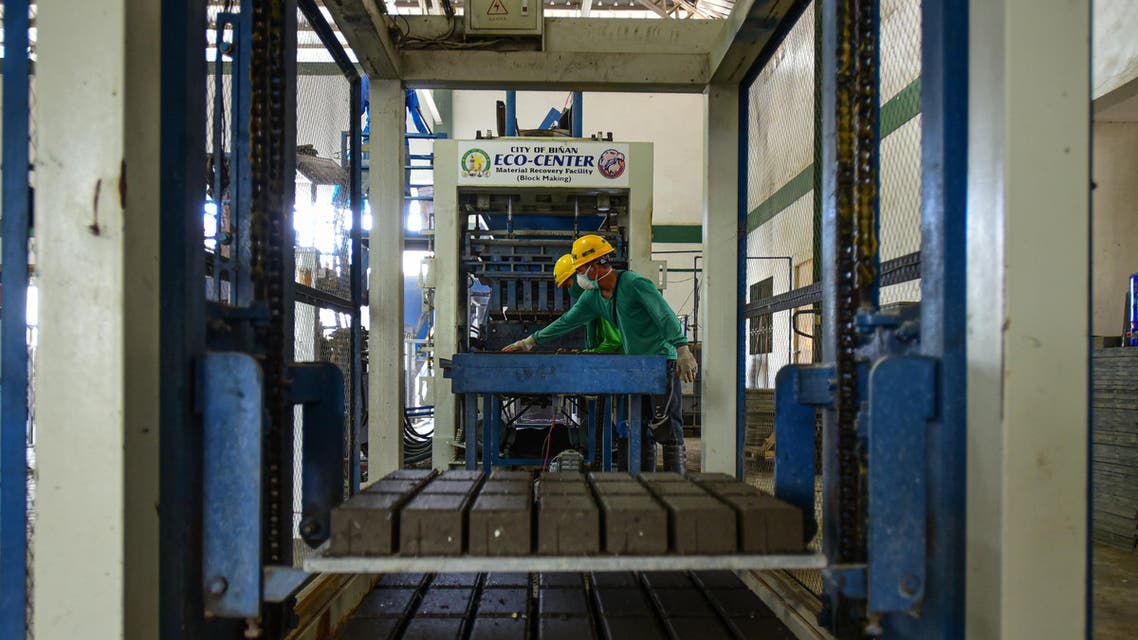 workers at the Binan City Materials and Recovery Facility (MRF) monitor the brick making process from collected volcanic ash (AFP)