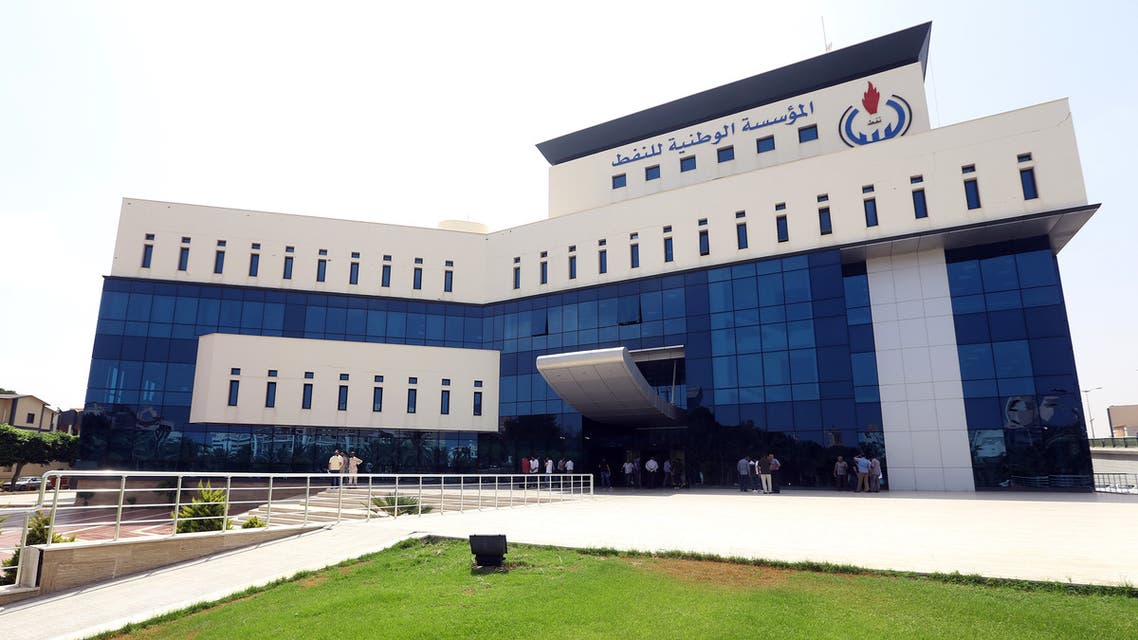 Onlookers gather in front of the headquarters of Libya's National Oil Company in the capital Tripoli on September 10, 2018. Armed men stormed the building in Tripoli today where a blast and gunfire were heard, witnesses and a security source said.