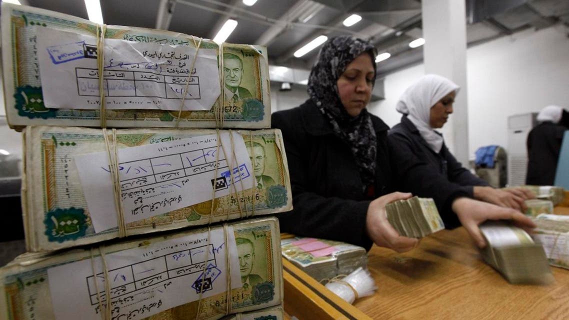 employees stack Syrian currency in the Central Bank, in Damascus, Syria. (AP)