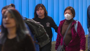 A woman arriving on a flight to Los Angeles International Airport wears a mask on the first day of health screenings for coronavirus of travelers from Wuhan, China. (AFP)