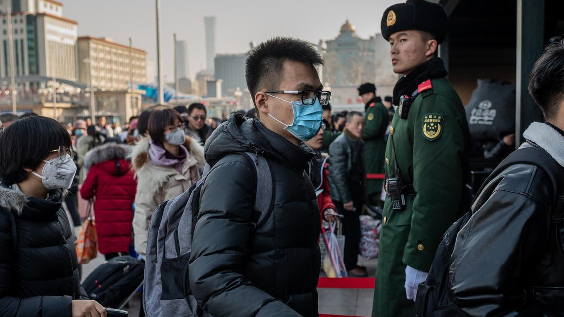 People wearing protective masks arrive at Beijing railway station to head home for the Lunar New Year on January 21, 2020. (AFP)