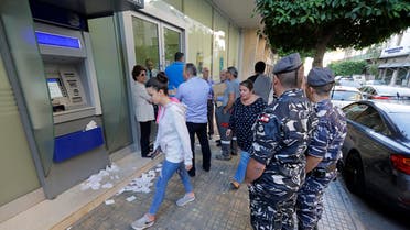 People await to enter a bank that has just reopened in the centre of the Lebanese capital Beirut. (AFP)