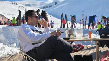 A man sips whiskey and smokes a cigar at a ski resort in Lebanon. (Greg Demarque)
