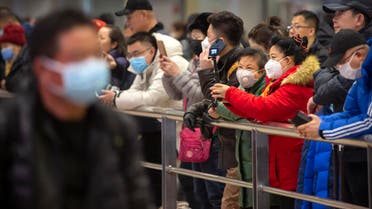 People wear face masks as they wait for arriving passengers at Beijing Capital International Airport on Jan. 23, 2020. (Photo: AP)