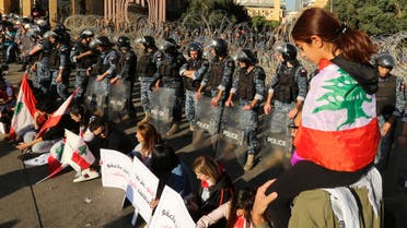 A girl has the national flag draped over her shoulders as riot police stand guard, during the ongoing anti-government protest, in Beirut, Lebanon, November 19, 2019. (Reuters)