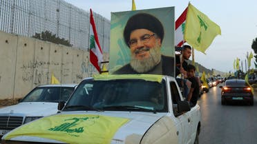 Supporters of Lebanon's Hezbollah leader Sayyed Hassan Nasrallah ride in a vehicle decorated with Hezbollah and Lebanese flags and a picture of him, as part of a convoy in Lebanon. (Reuters)