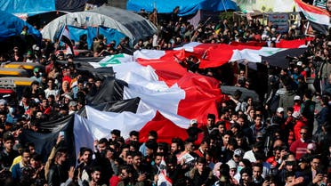 Anti-government protesters hold a huge Iraqi flag as they gather during a protest in Tahrir Square in Baghdad on Jan. 26, 2020. (AP)
