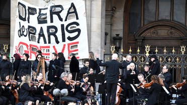 Musicians perform in front of the Palais Garnier during a demonstration of striking employees of the Opera Garnier and the Comedie Francaise, against the French government's plan to overhaul the country's retirement system in Paris (AFP)