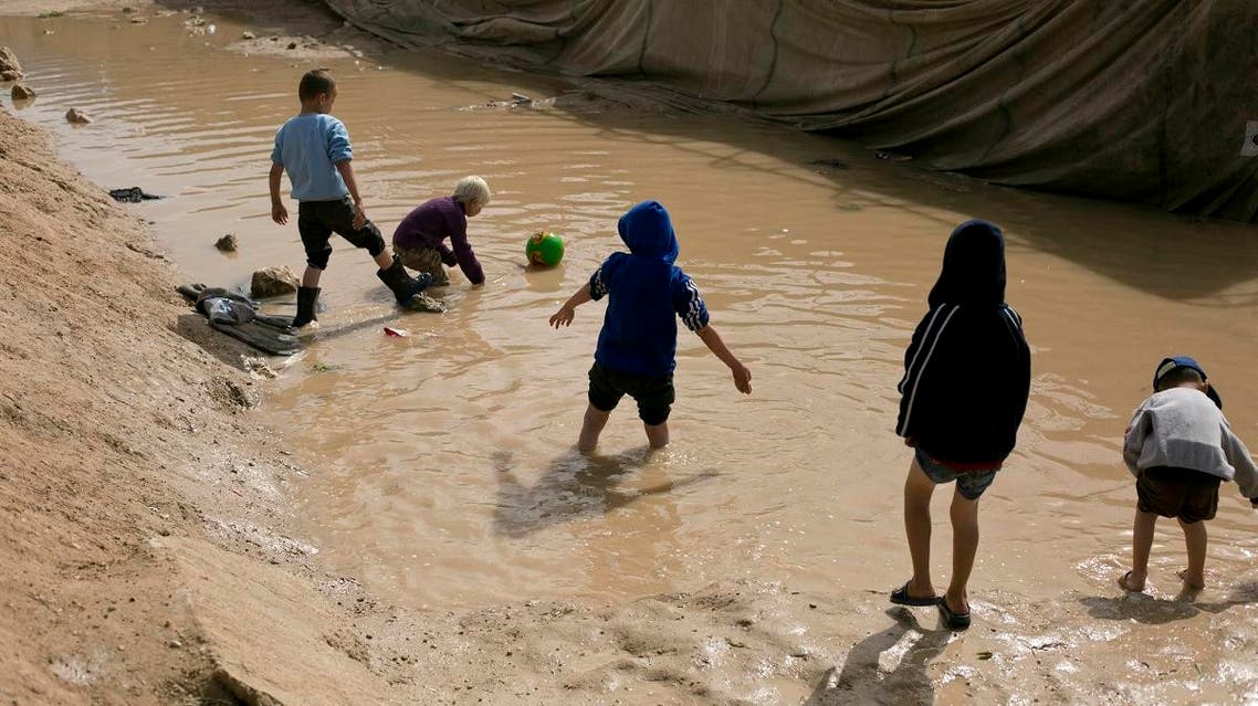 In this March 31, 2019, photo, children play in a mud puddle in the section for foreign families at Al-Hol camp in Hassakeh province, Syria. (AP)