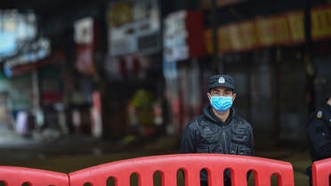 A security guard stands outside the Huanan Seafood Wholesale Market where the coronavirus was detected in Wuhan on January 24, 2020. The death toll in China's viral outbreak has risen to 25, with the number of confirmed cases also leaping to 830, the national health commission said.
