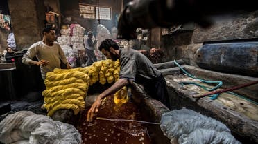 Workers dye yarns at a traditional hand-dying workshop in the Egyptian capital Cairo's centuries old district of Darb al-Ahmar on January 21, 2020. (AFP)