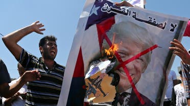 Palestinian demonstrators burn a crossed-out poster depicting U.S. President Donald Trump and reading: "no for Deal of the Century" during a protest against Bahrain's workshop for U.S. Middle East peace plan, in the southern Gaza Strip, June 26, 2019. (Reuters)