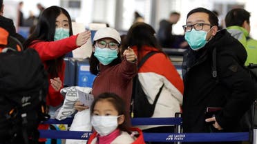 Passengers wearing masks wait in a line to check-in to a flight to Shanghai at the Vaclav Havel International Airport in Prague, Czech Republic, on January 27, 2020. (AP)