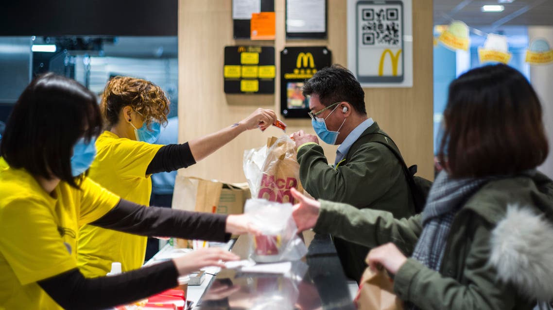 Members of staff (L) and customers (R) wear face masks at the counter of a MacDonald's fast food restaurant in Hong Kong. (AFP)