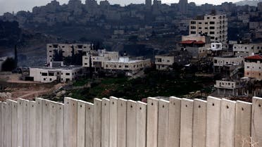 A general view shows the West Bank city of Abu Dis (background) behind Israel's controversial separation barrier dividing the Palestinian neighbourhood of Al-Tur in the Israeli annexed East Jerusalem with the West Bank, on February 11, 2016.