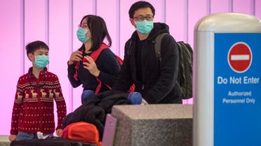 مسافرون يرتدون الأقنعة خوفاً من كورونا خلال تواجدهم في أحد المطارات الأميركية قادمين من آسيا(فرانس برس)