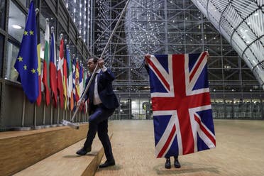 EU Council staff members remove the United Kingdom’s flag from the European Council building in Brussels on Brexit Day, on January 31, 2020.  (AFP)