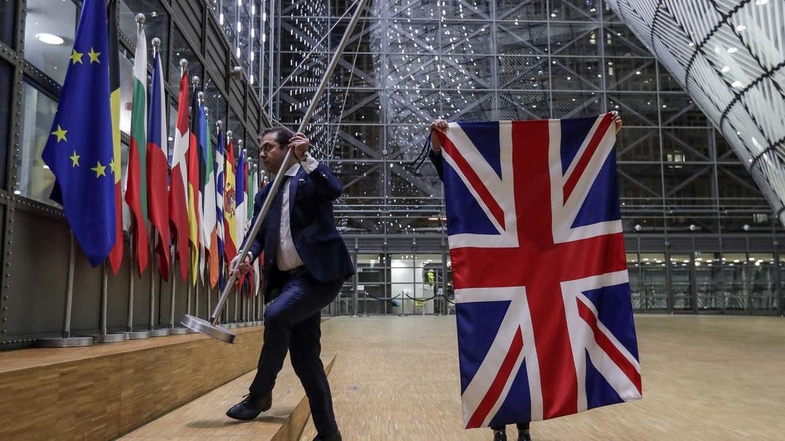 EU Council staff members remove the United Kingdom’s flag from the European Council building in Brussels on Brexit Day, on January 31, 2020. (AFP)