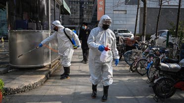 People dressed in protective clothes disinfect an area in Wuhan, in Hubei province on January 30, 2020. (AFP)