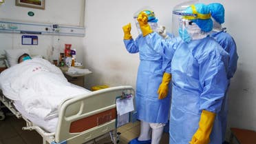 This photo taken on January 28, 2020 shows medical staff members cheering up a patient infected by the novel coronavirus in an isolation ward at a hospital in Zouping in China’s easter Shandong province. (AFP)