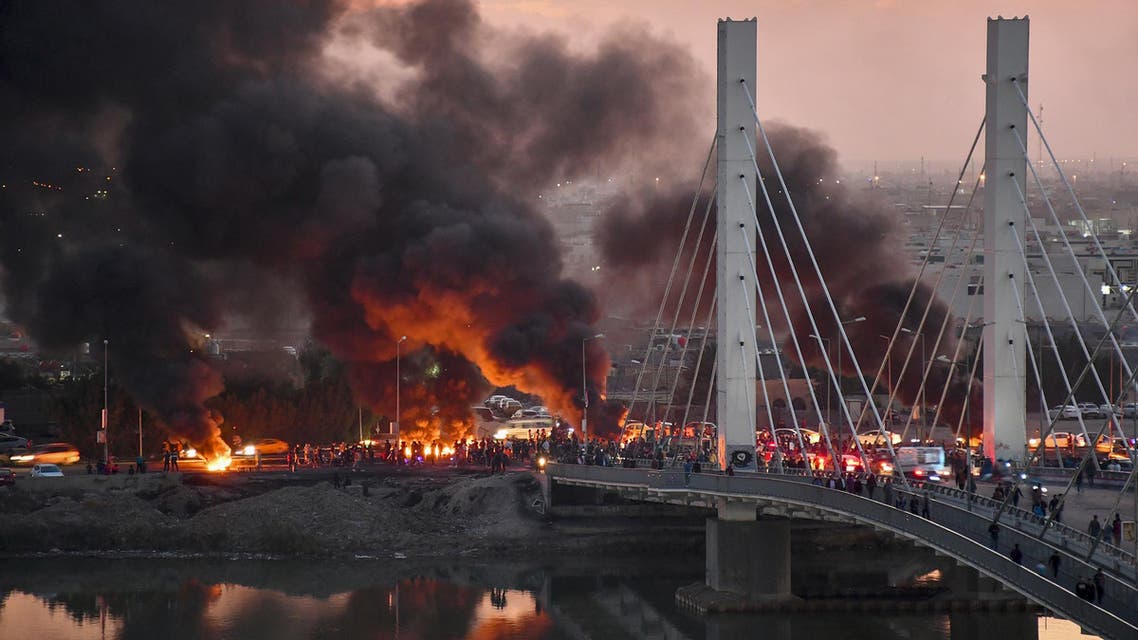 Anti-government demonstrators block a bridge with debris and burning tires in the southern Iraqi city of Nasiriyah on January 19, 2020. (AP)