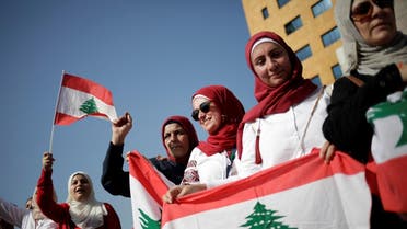 Women carry national flags during ongoing anti-government protests near the Ministry of Education and Higher Education in Beirut, Lebanon November 7, 2019. REUTERS