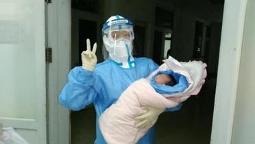 طبيب يحمل الطفلة بعد ولادتها