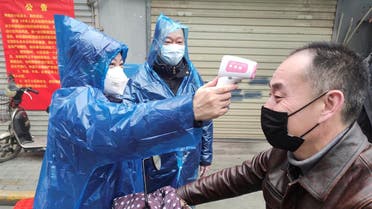 Worker takes body temperature measurement of a man at the entrance to a residential compound following an outbreak of the new coronavirus in Wuhan. (Reuters)