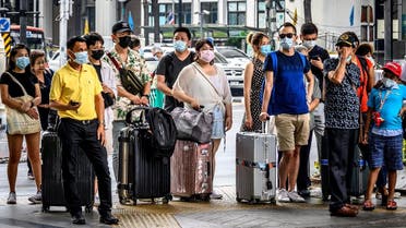 People with protective facemasks wait at a crossroad in downtown Bangkok on February 3, 2020. (Photo: AFP)