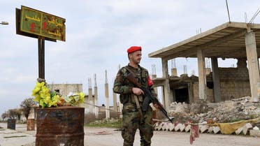 A Syrian Army soldier stands guard next to a street sign reading "Saraqeb" in Tall Sultan town, in Syria's northwestern Idlib province on February 5, 2020. (AFP)