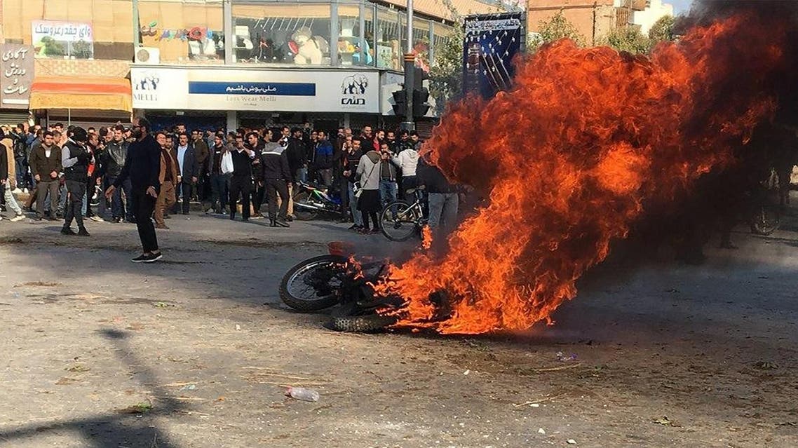 Iranian protesters gather around a burning motorcycle during a demonstration against an increase in gasoline prices in the central city of Isfahan, on November 16, 2019. (AFP)