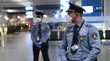 Police oficers wearing protective face masks stand on guard in the hall of Budapest's Liszt Ferenc Airport of on February 5, 2020. (AFP)