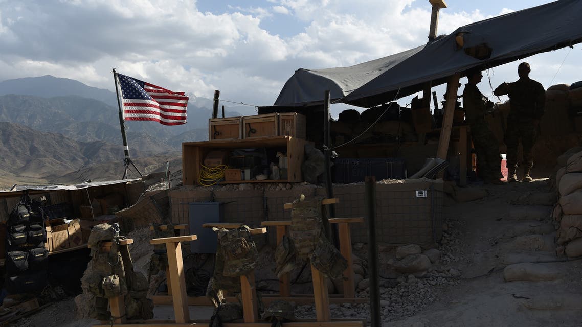 (FILES) In this file photograph taken on July 7, 2018, US Army soldiers from NATO look on as U.S. flag flies at a checkpoint during a patrol against Islamic State militants at the Deh Bala district in the eastern province of Nangarhar Province. Two American troops were killed and six others wounded when an Afghan soldier armed with a machine gun opened fire, the US military confirmed on February 9.