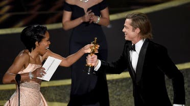 Regina King (left), presents Brad Pitt with the award for best performance by an actor in a supporting role for “Once Upon a Time in Hollywood” at the Oscars on February 9, 2020, at the Dolby Theatre in Los Angeles. (AP)