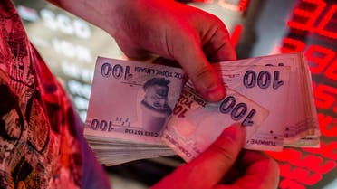 A money changer counts Turkish lira banknotes at a currency exchange office in Istanbul. (AFP)