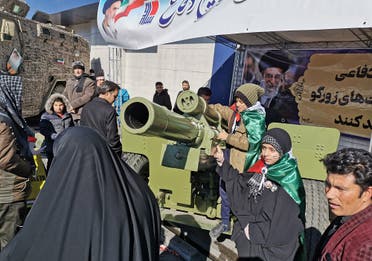 Iranian children pose with howitzer artillery gun during commemorations marking 41 years since the Islamic Revolution. (AFP)